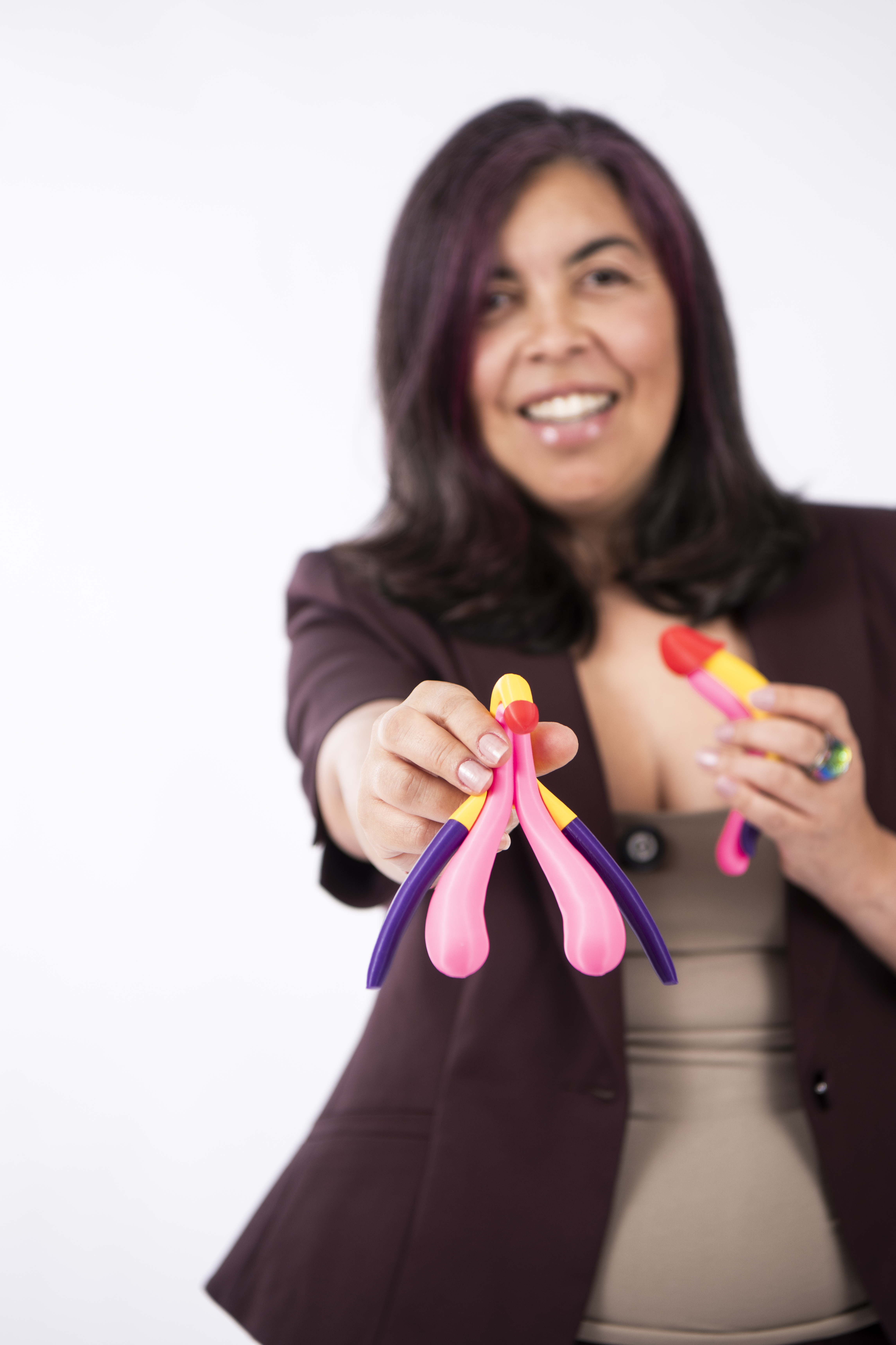 Cris de Andrade holding clitoris and uterus anatomy models