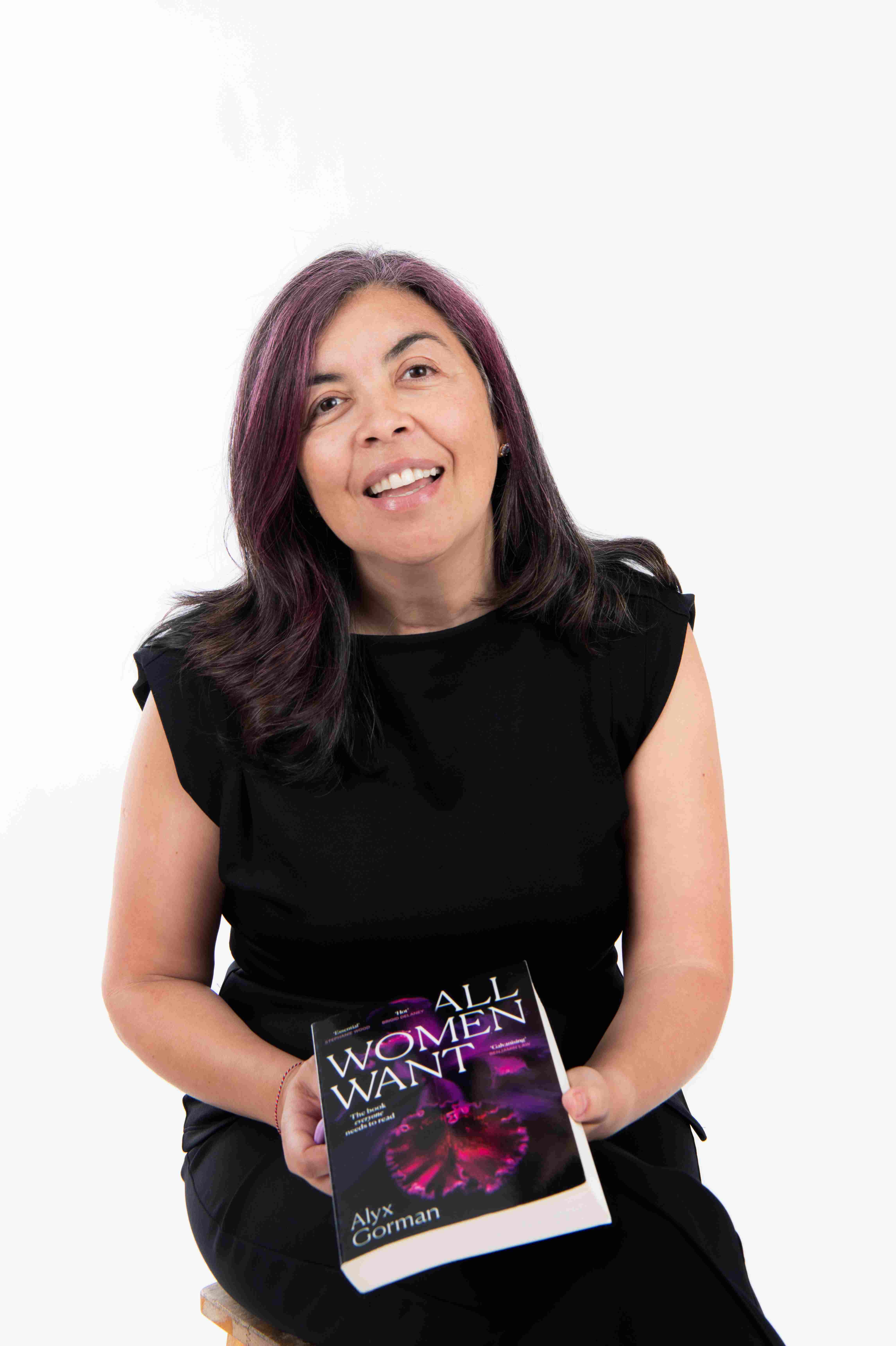Cris De Andrade holding All Women Want by Alyx Gorman